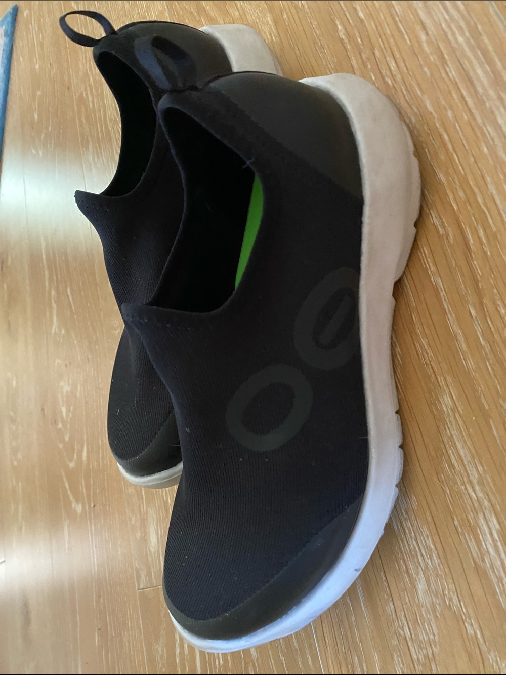 OOFOS Black Slip-On Women's Sneakers with White Sole.